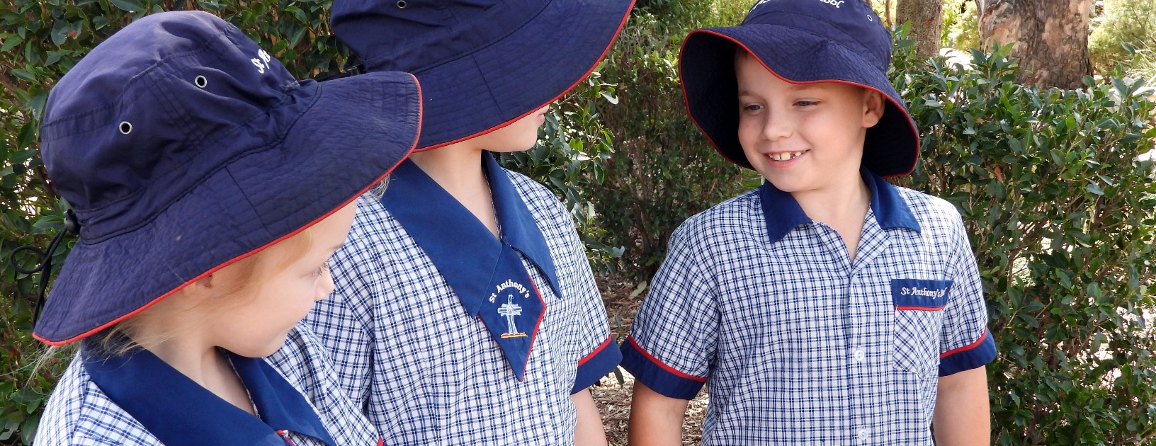students in school uniform wearing hats interacting together outdoors, representing friendship, connection and a supportive school community